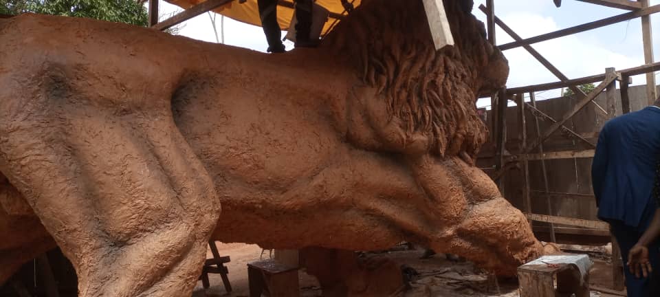 Lion de Nsimalen — vue de profil, sculpture monumentale en cours de réalisation