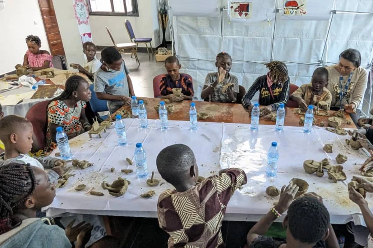 Vue d'ensemble de l'atelier modelage argile — enfants et intervenants autour de la table